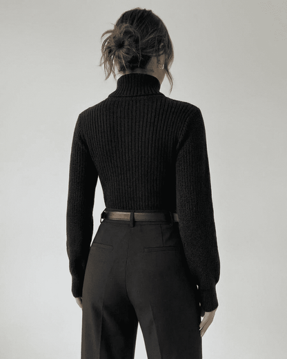 Woman wearing the Sarina Sweater by Slimona, showcasing the back view with a mock neck and ribbed texture.