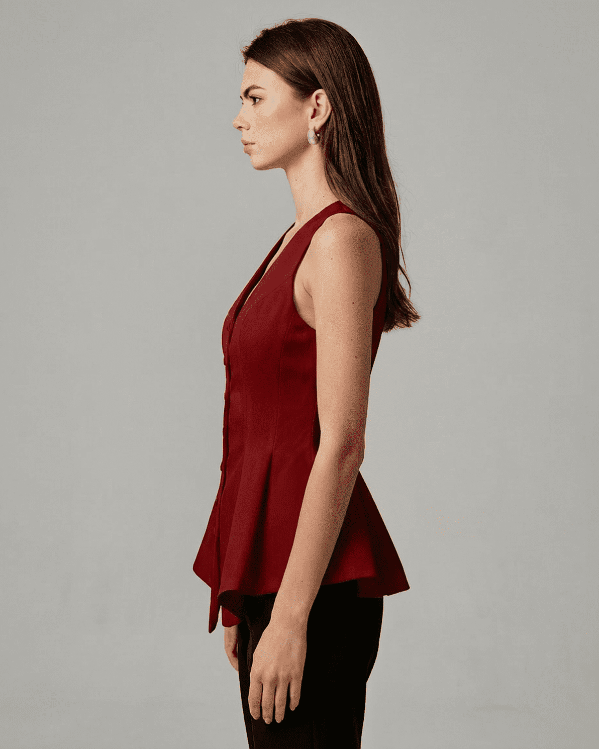 Scarlett Blouse by Slimona, elegant satin sleeveless top in rich red with tailored peplum silhouette.