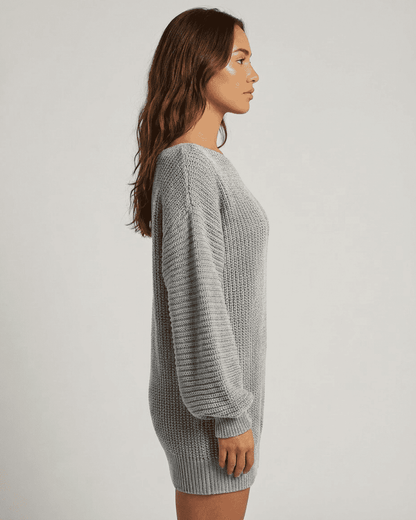 Selene Mini Dress by Slimona in grey ribbed knit with off-the-shoulder lantern sleeves styled in a side profile view.