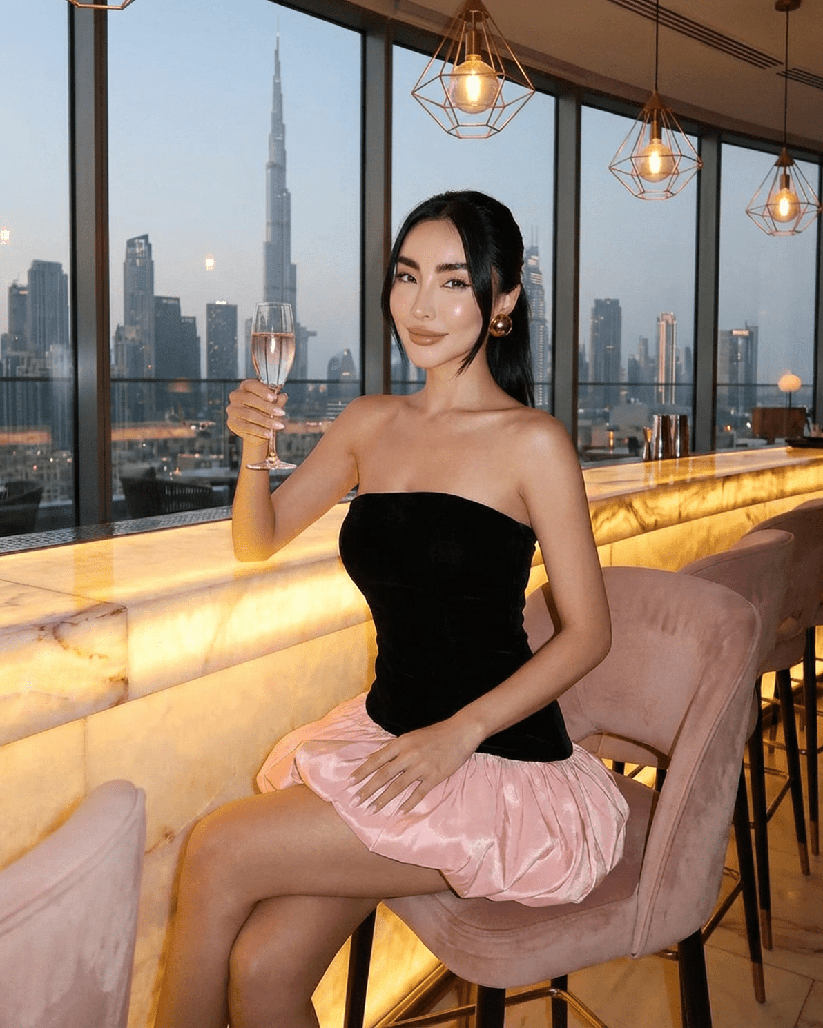 Selina Mini Dress by Slimona, featuring a strapless black velvet top and a playful pink puff skirt, against a city skyline.