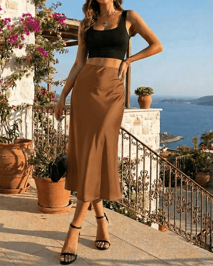 Siena Midi Skirt by Slimona, showcasing fluid satin drape and high-waisted silhouette against a scenic backdrop.