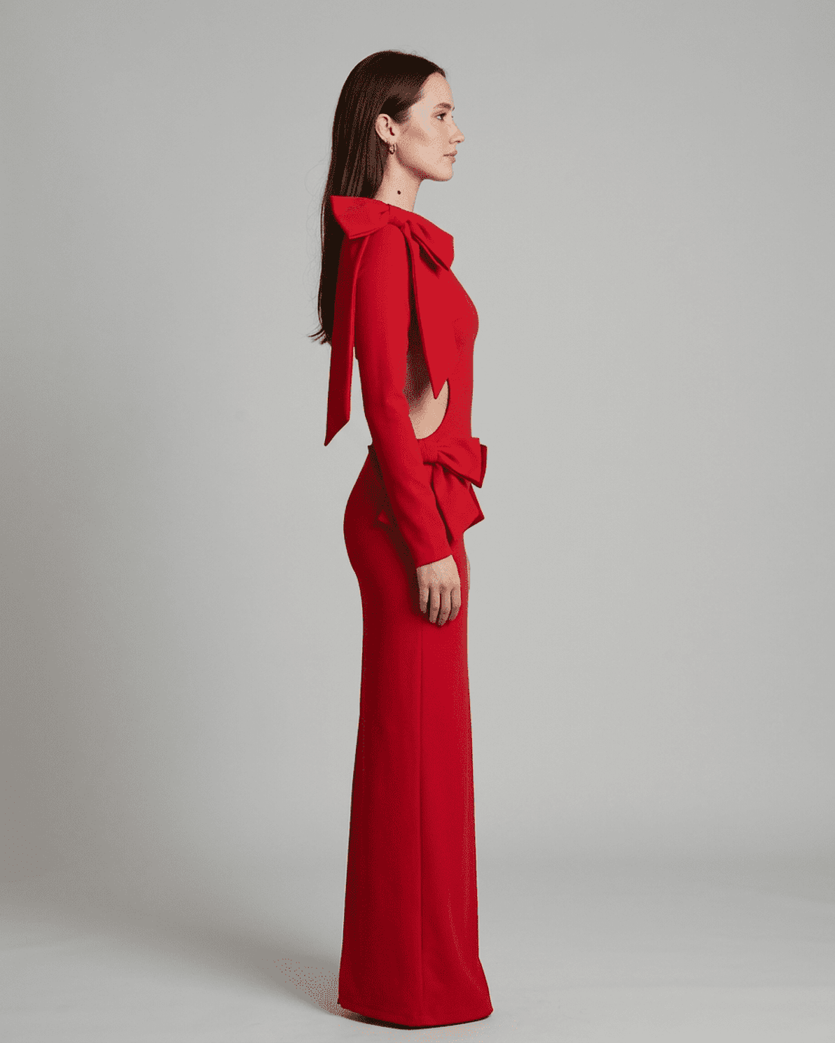 Valencia Maxi Dress by Slimona, showcasing long sleeve bodycon silhouette with cut-out waist and sculptural bows, in red.