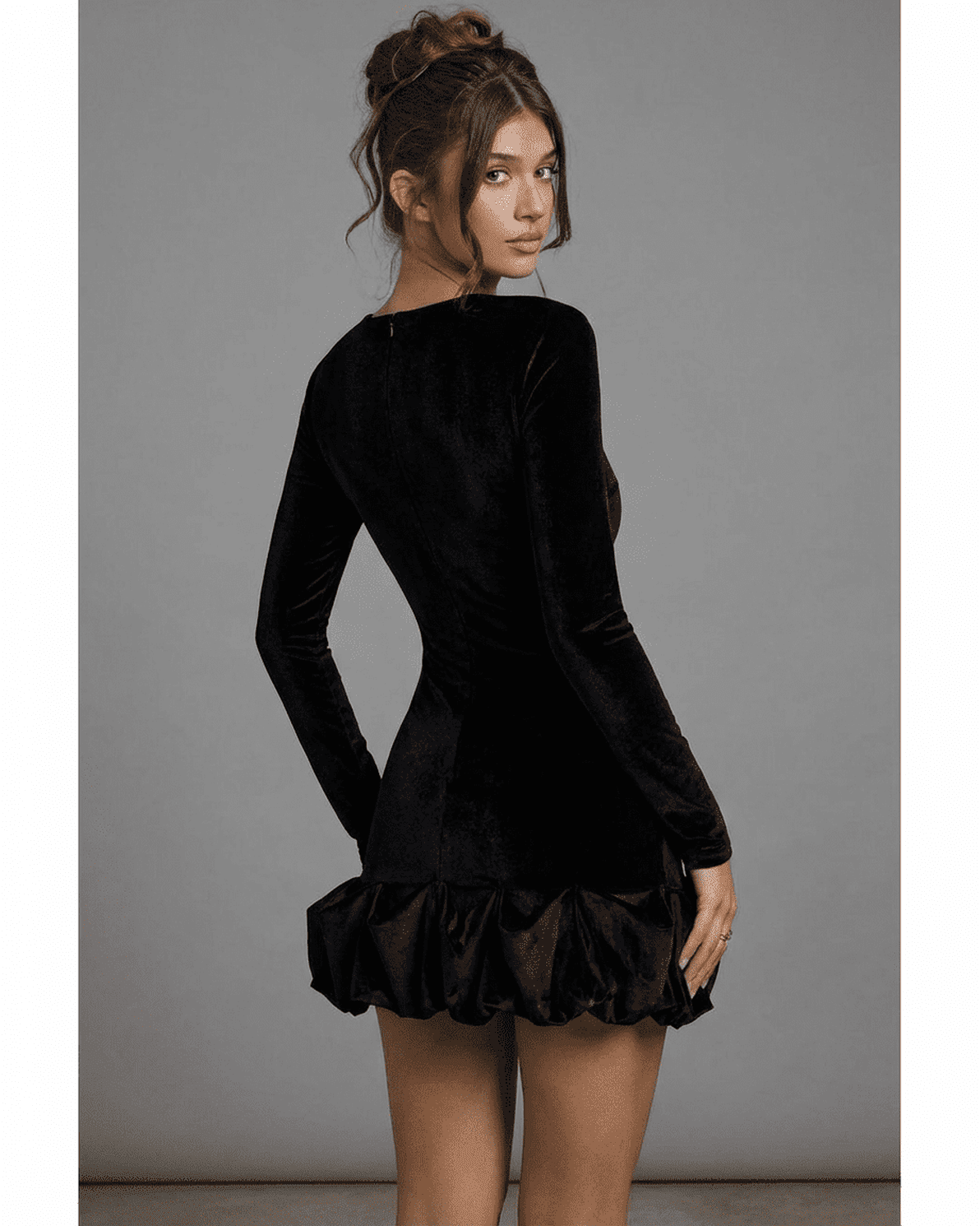 Velora Mini by Slimona – Black velvet bodycon dress with long sleeves and pleated hem, showcasing a luxe silhouette.