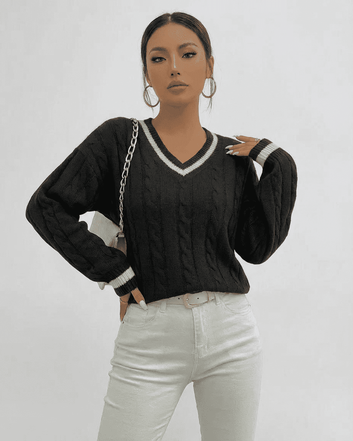 Model wearing Slimona Verona Sweater in black cable knit with V-neck and white accents.