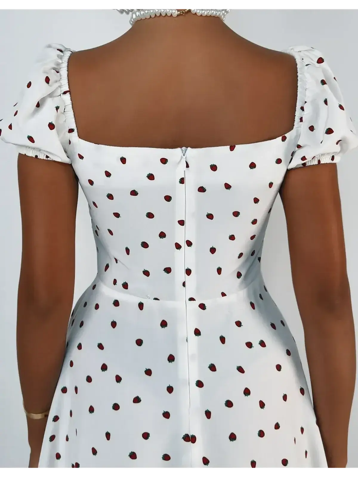 Back view of a white mini dress with puff sleeves and red polka dots, perfect for summer dresses or wedding guest outfits.