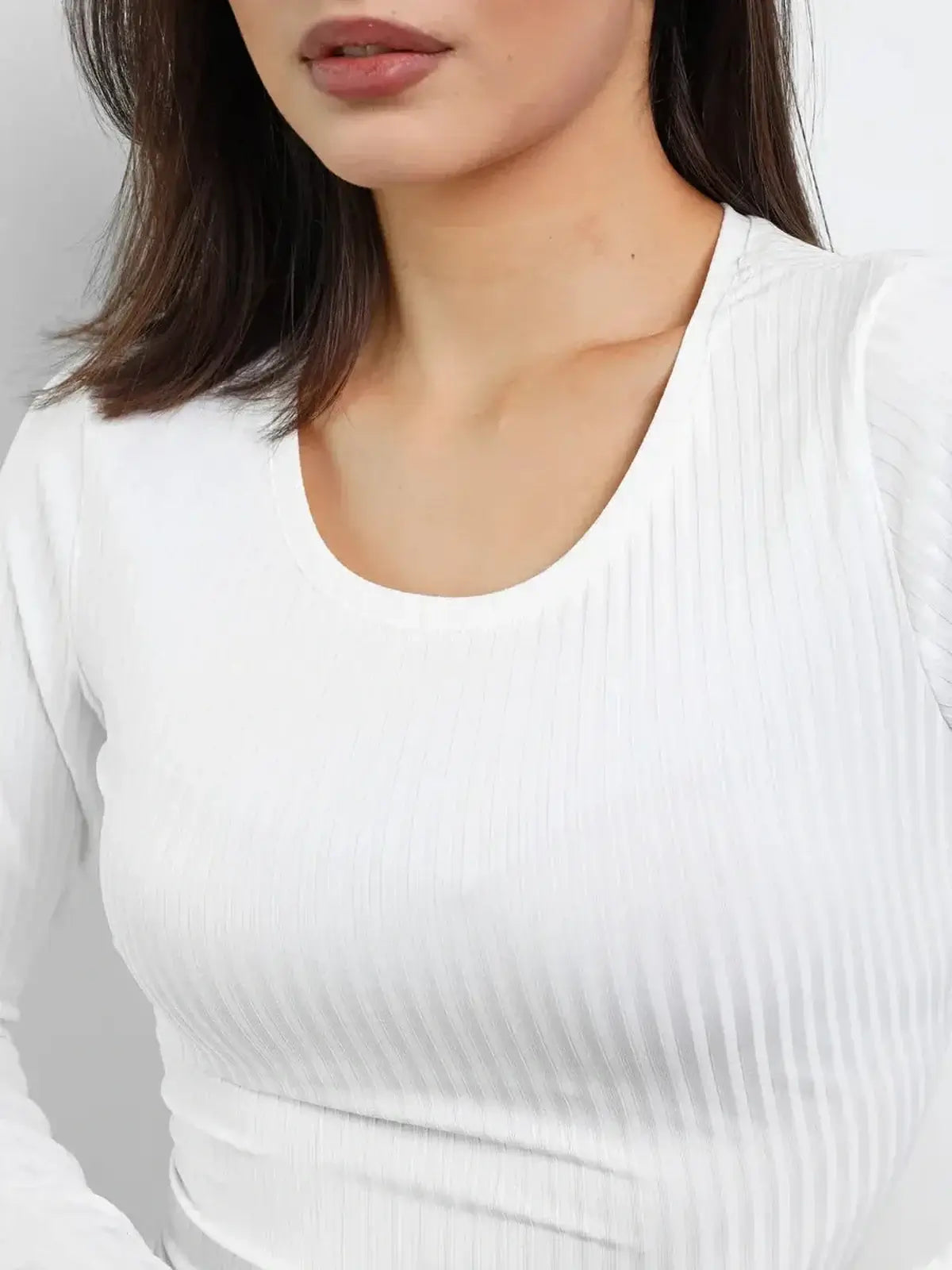 Close-up of a woman's white ribbed knit dress, featuring a scoop neckline and flattering fit for wedding guest or summer occasions.