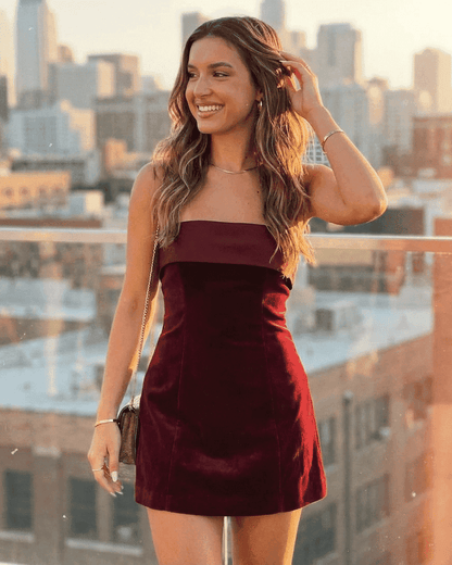 Model wearing a Luxe Mini Dress by Slimona, showcasing the classy velvet style against a city skyline backdrop.