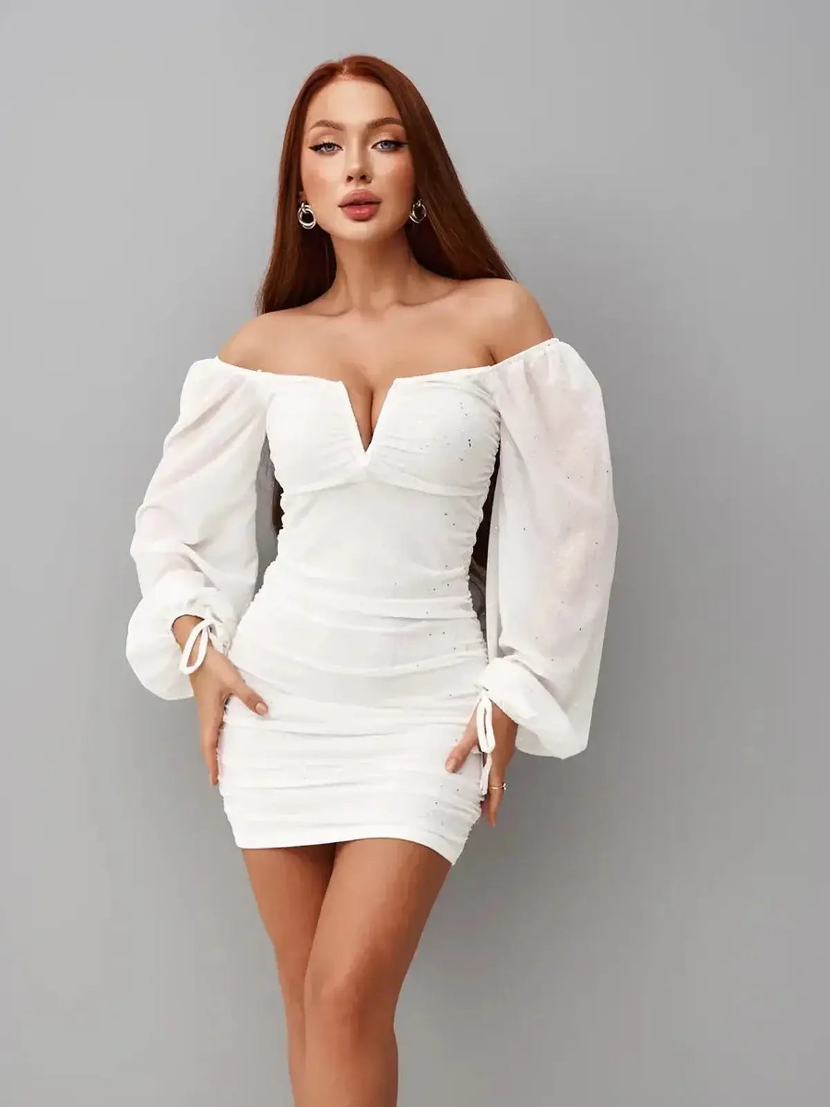 Dazzling white mini dress with off-the-shoulder neckline and ruched bodice, perfect for summer and wedding guest attire.