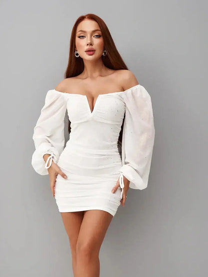 Dazzling white mini dress with off-the-shoulder neckline and ruched bodice, perfect for summer and wedding guest attire.