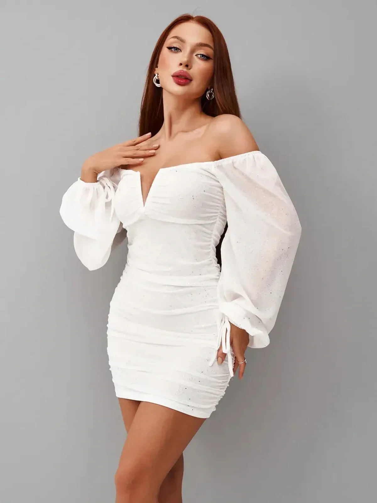Model wearing a white mini dress with off-the-shoulder sleeves and a deep V-cut, perfect for summer parties and weddings.