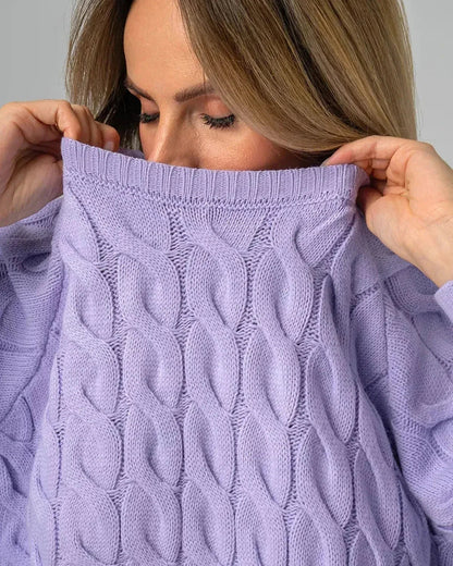 Model wearing the Lyra Sweater by Slimona, showcasing its oversized lavender knit and modern cable design.