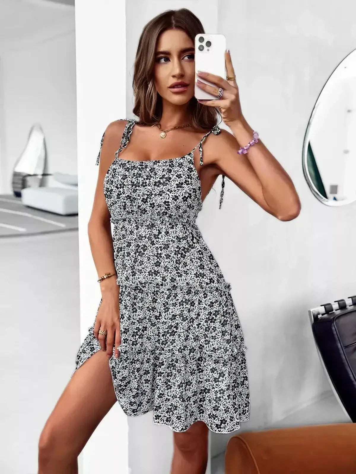 Black floral mini dress with adjustable spaghetti straps, perfect for summer outings and casual events.