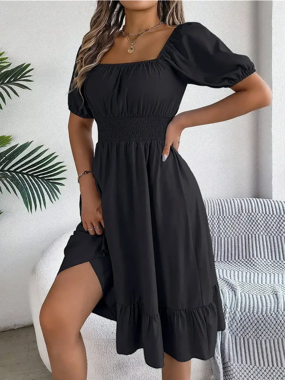 Black mini dress with square neckline and puff sleeves, perfect for summer or formal occasions.