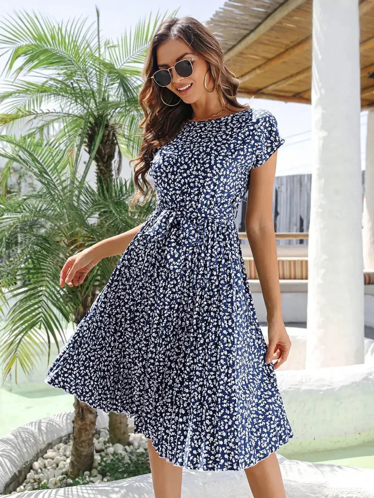 Woman wearing a floral midi dress in navy blue, perfect for summer, weddings, and casual outings.