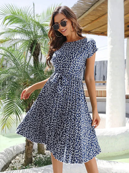 Woman wearing a floral midi dress in navy blue, perfect for summer, weddings, and casual outings.
