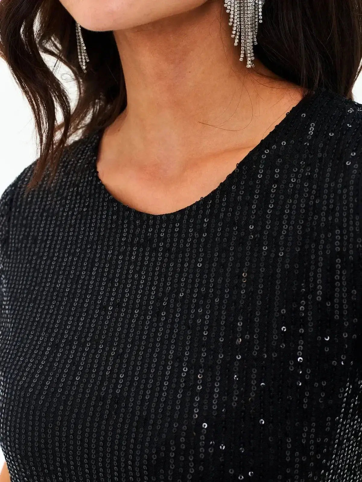 Close-up of a sparkling black sequin dress showcasing its luxurious texture and elegant design.