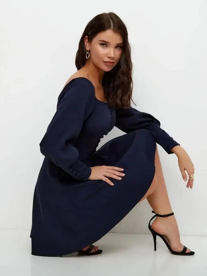 Model wearing the Midnight Grace Mini Dress in navy, featuring a square neckline and long sculptural sleeves.