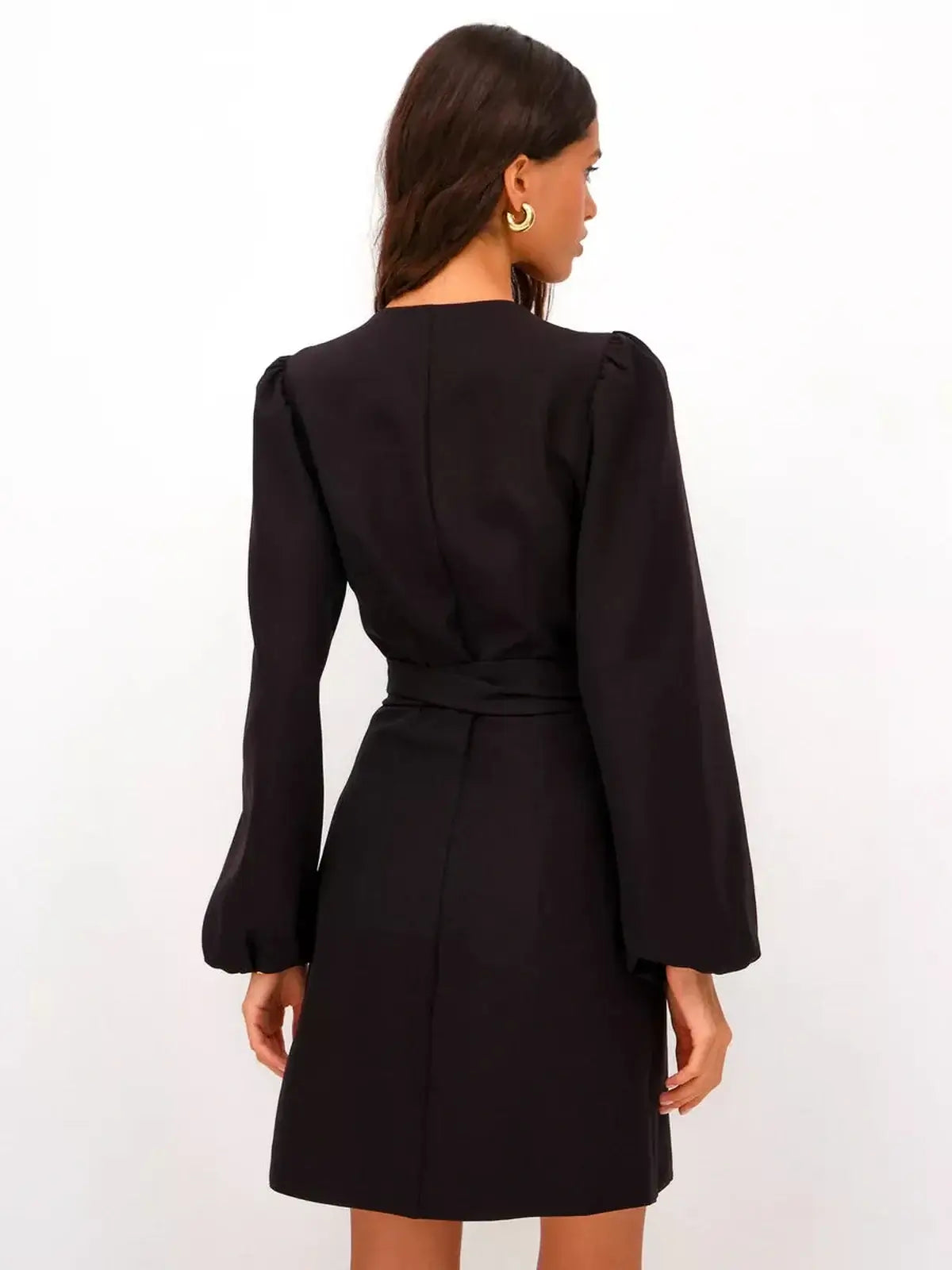 Back view of a model in a black midnight kimono mini dress with long sleeves and a cinched waist.