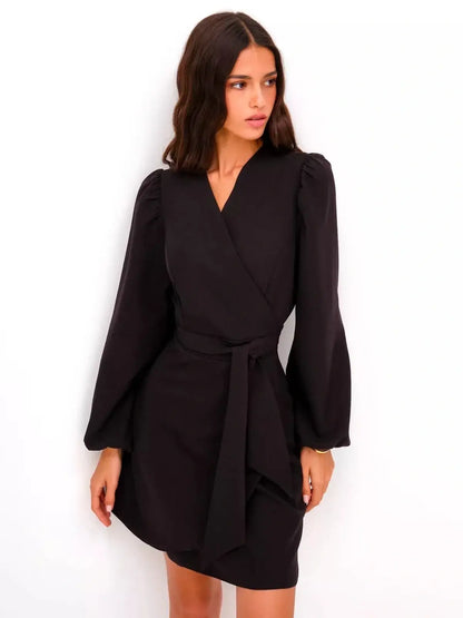Model wearing a black midi dress with a wrap silhouette and bell sleeves, perfect for formal and cocktail occasions.