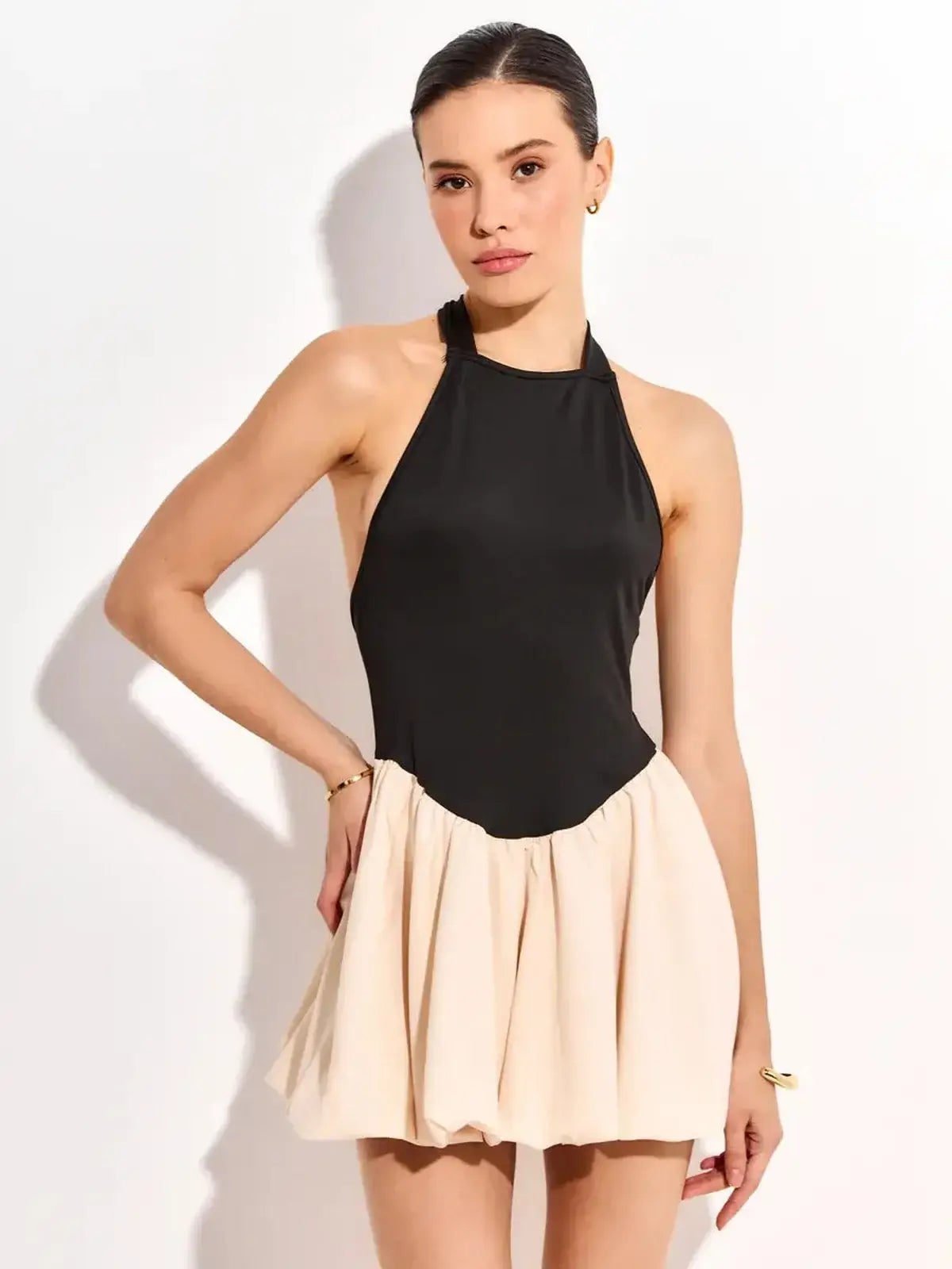 Elegant black and beige mini dress with halter neck design, perfect for summer parties and formal occasions.