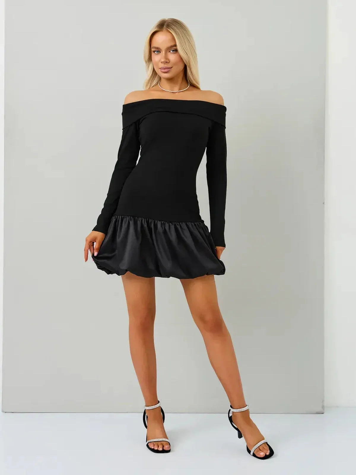 Model wearing the Midnight Petal off-the-shoulder black mini dress with balloon skirt, perfect for parties and weddings.