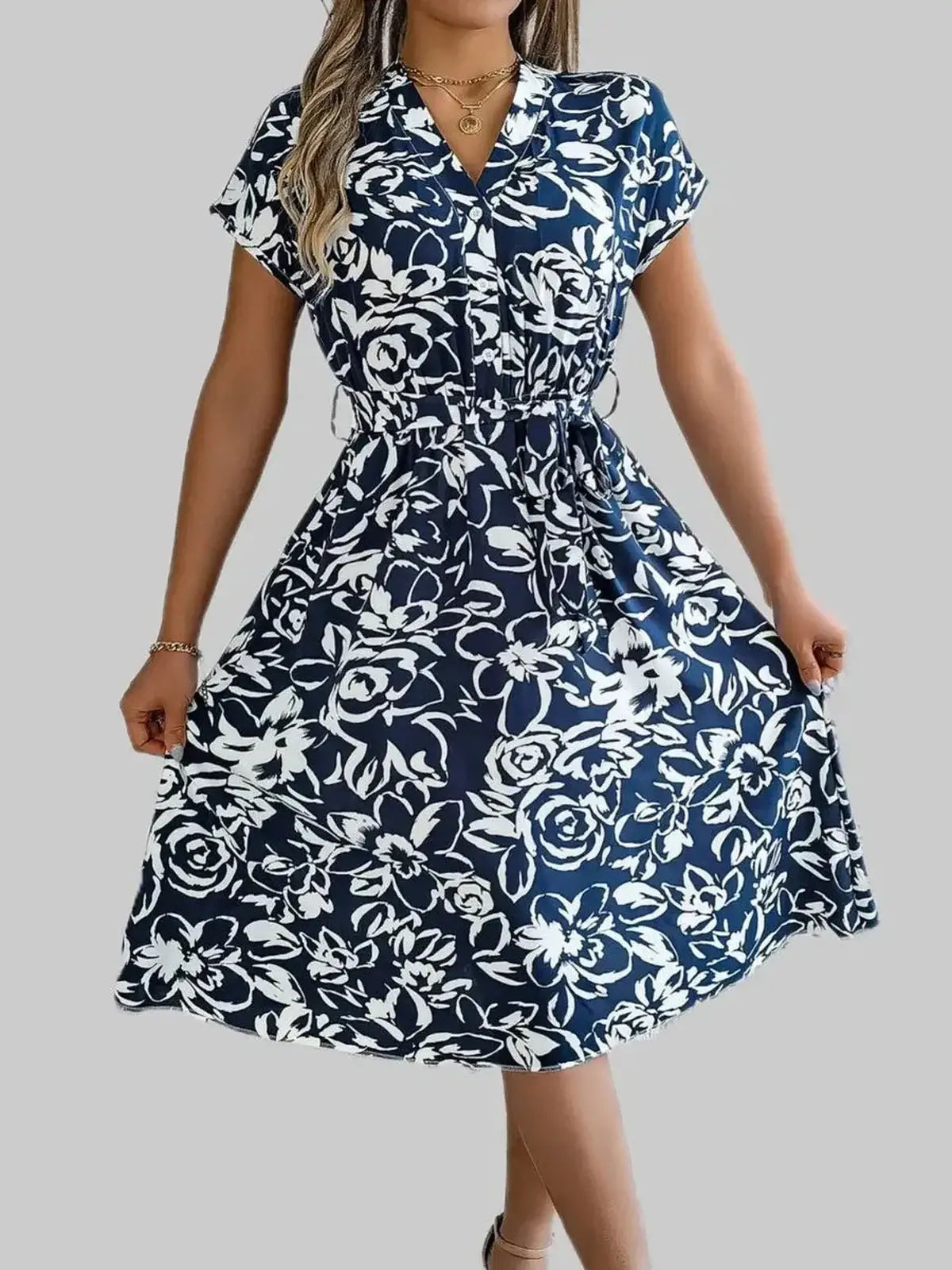 Elegant navy floral midi dress with a V-neckline and cinched waist, perfect for summer and special occasions.