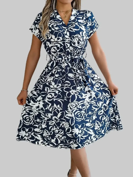 Elegant navy floral midi dress with a V-neckline and cinched waist, perfect for summer and special occasions.
