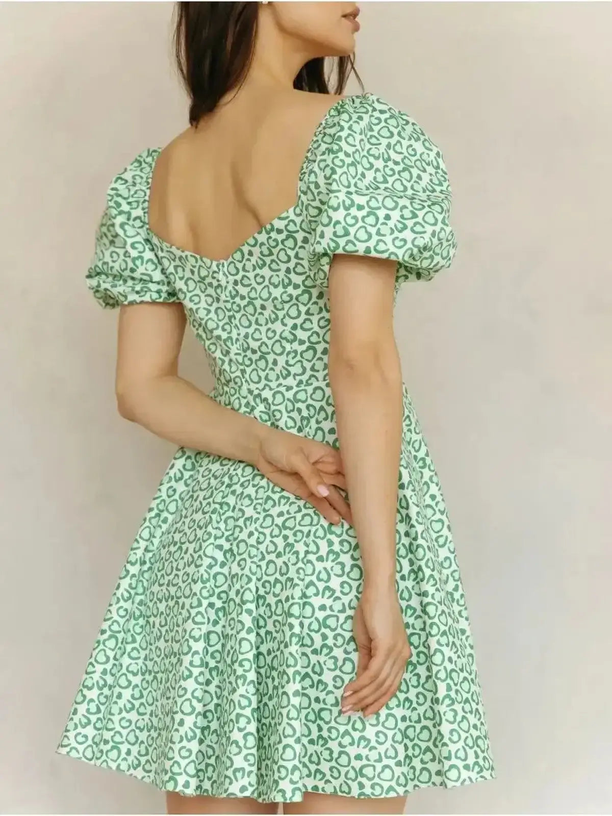 Back view of Mint Muse Mini Dress featuring puff sleeves and a playful green heart-leopard print, perfect for summer.