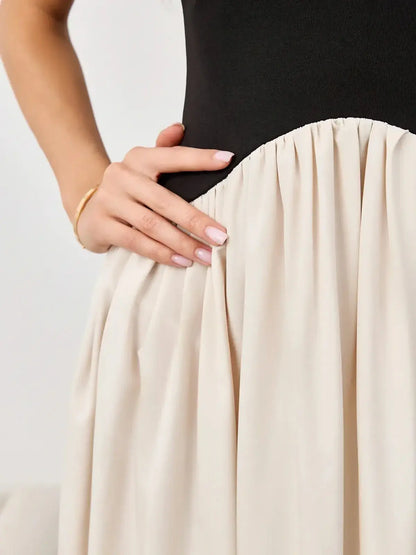 Close-up of the Muse Hourglass dress showing black bodice and flowing beige skirt for stylish evening wear.