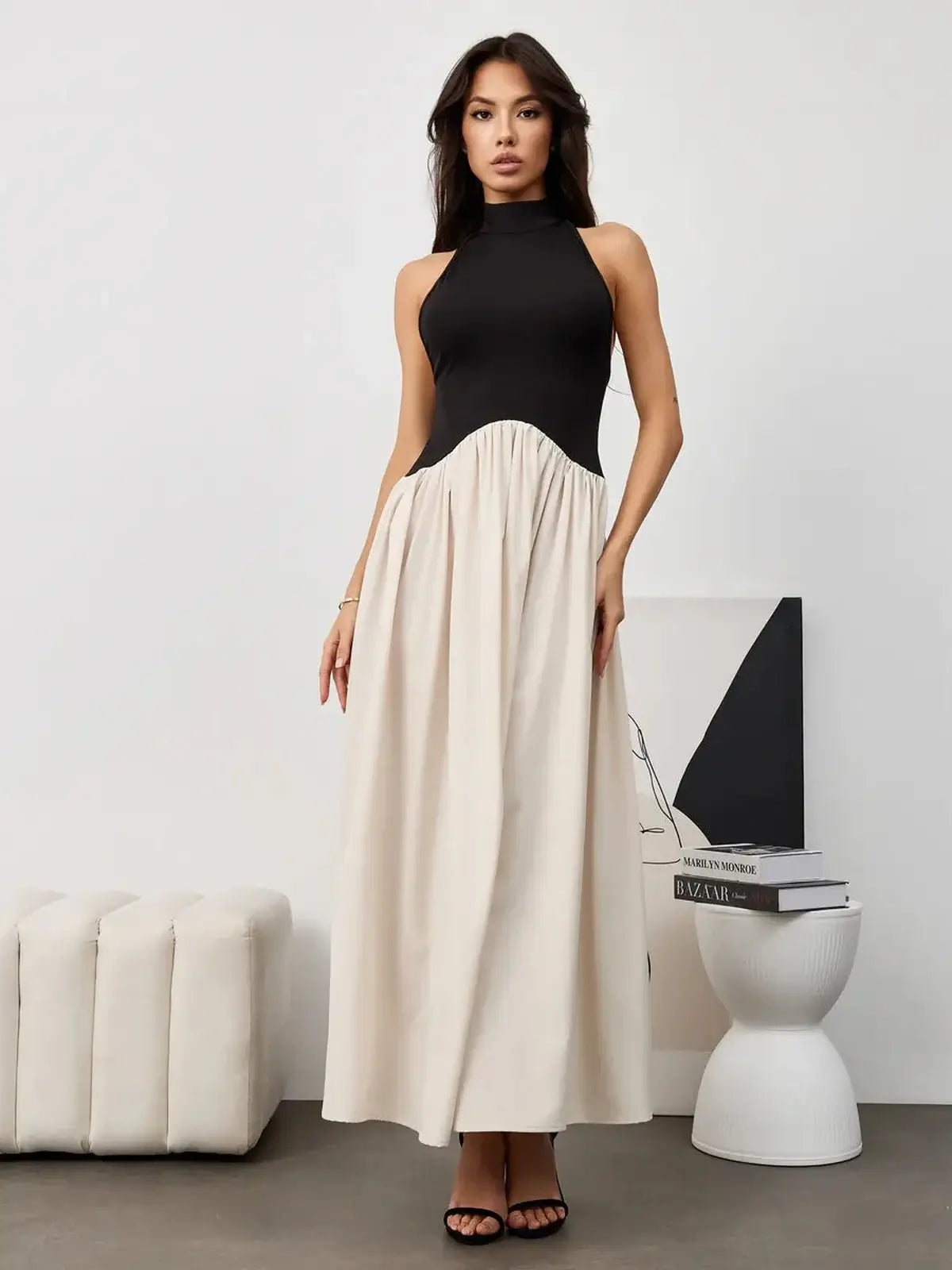 Elegant Muse Hourglass midi dress with a black halter bodice and flowing beige skirt, perfect for evening events.