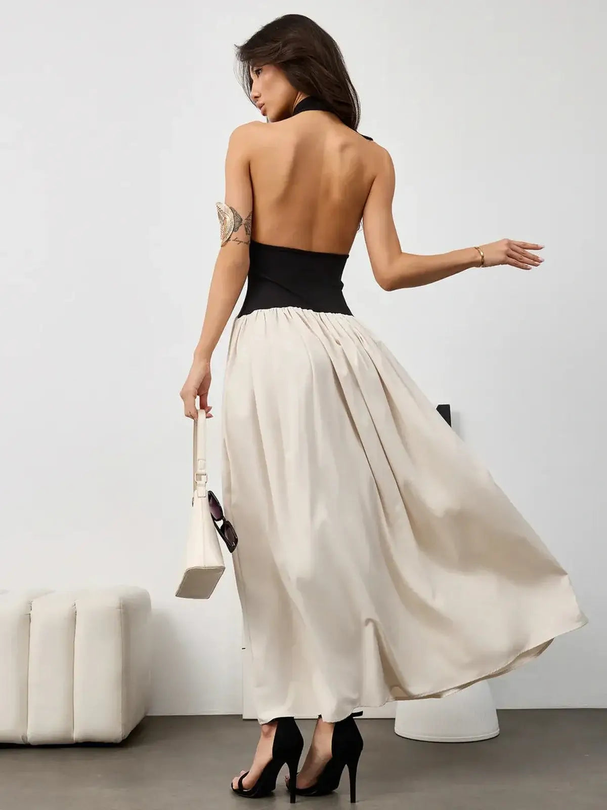 Chic Muse Hourglass midi dress featuring a halter black bodice and flowing beige skirt, perfect for evening wear.