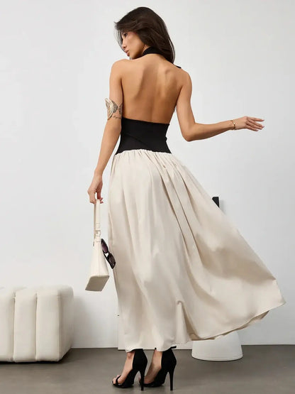 Chic Muse Hourglass midi dress featuring a halter black bodice and flowing beige skirt, perfect for evening wear.