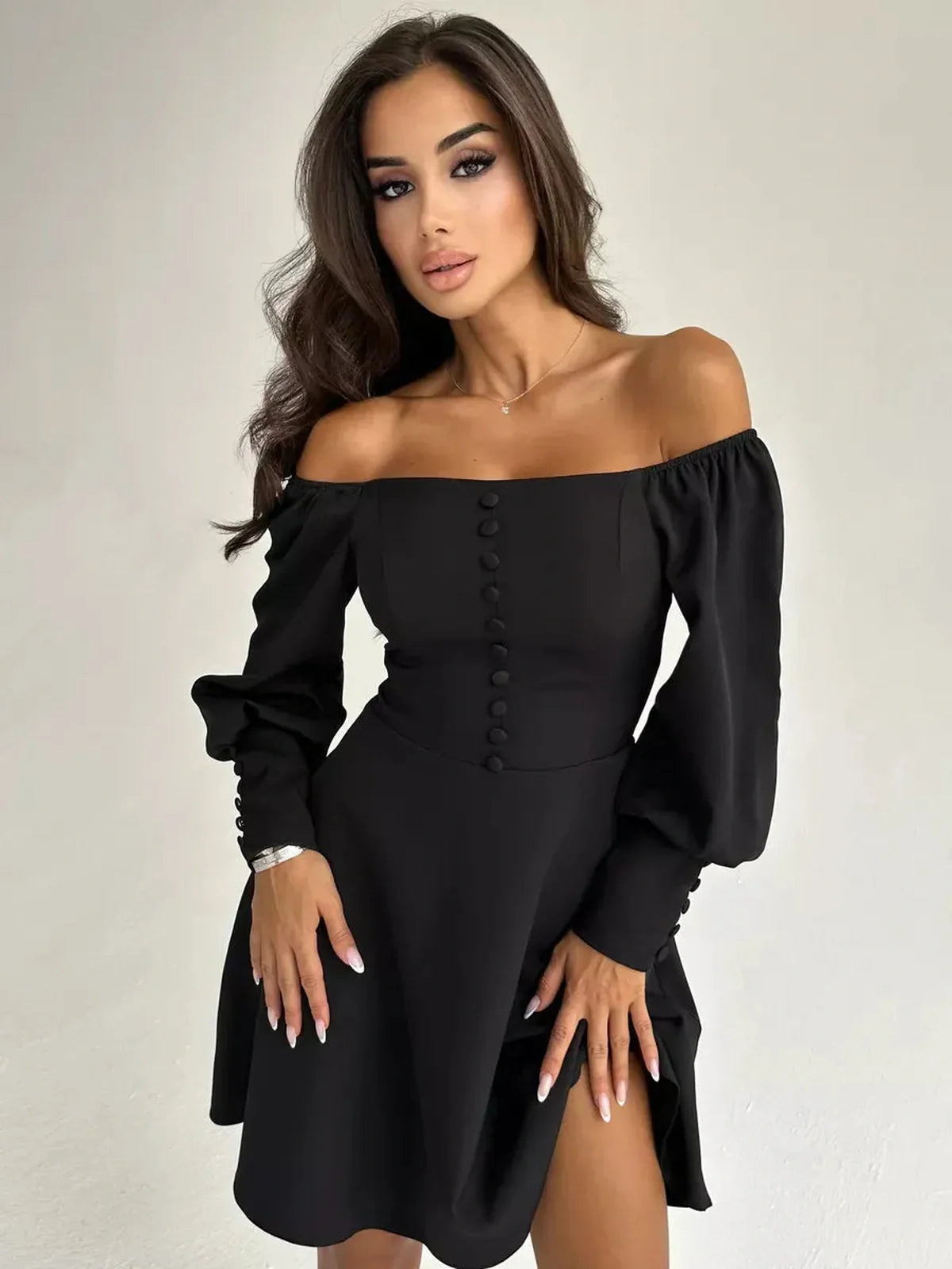 Sleek Noir Aura Mini Dress with off-shoulder design and button detail, perfect for summer evenings and special occasions.