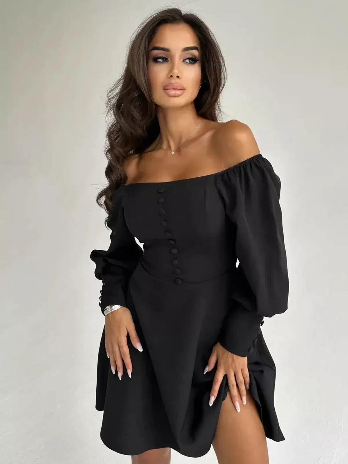 Black mini dress with off-the-shoulder sleeves and button-down detail, ideal for evening wear and stylish outings.
