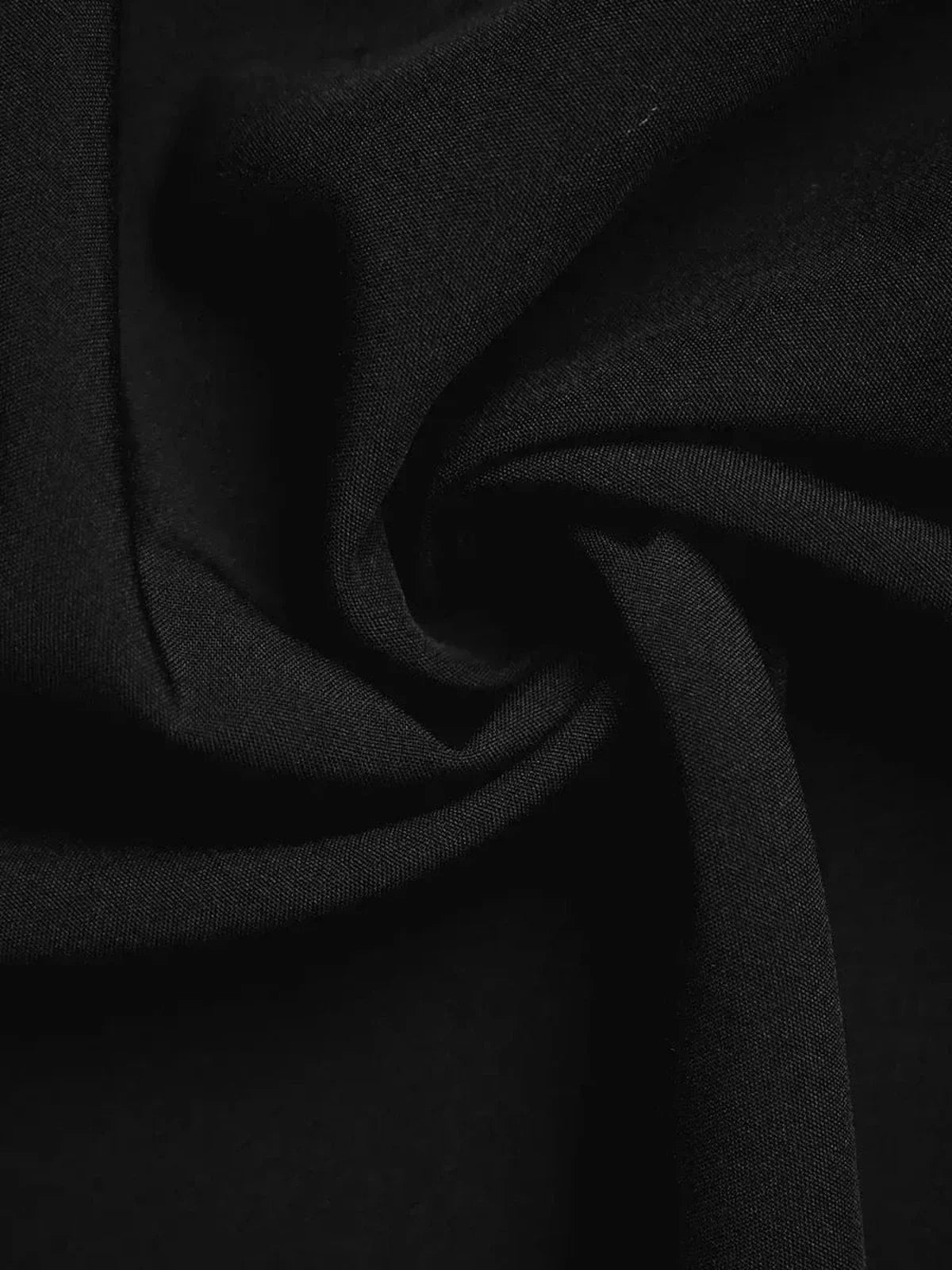Close-up of soft, black fabric showcasing luxurious texture ideal for formal and evening dresses.