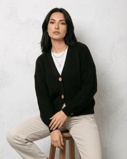 Noir Cardigan by Slimona, a sleek black knitwear piece featuring a classic V-neck and button detail.