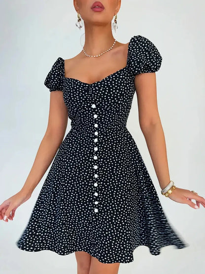 Noir Chic Mini Dress in black with white dots, featuring a sweetheart neckline and puff sleeves, perfect for summer occasions.