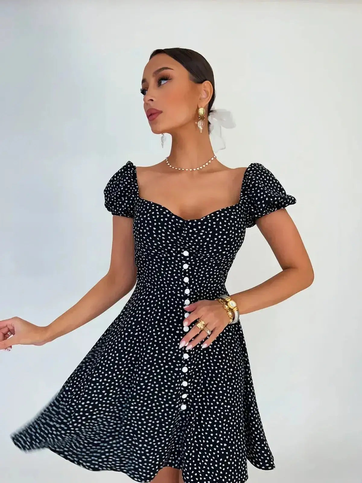 Noir Chic Mini Dress in black with white dots, featuring a sweetheart neckline and flared skirt, perfect for summer.