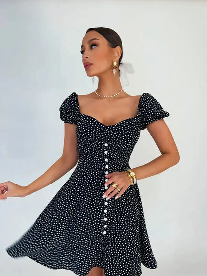 Noir Chic Mini Dress in black with white dots, featuring a sweetheart neckline and flared skirt, perfect for summer.