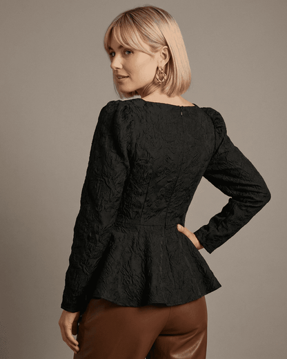 Elegant back view of Noir Corset Top by Slimona, featuring structured jacquard fabric and puff sleeves.
