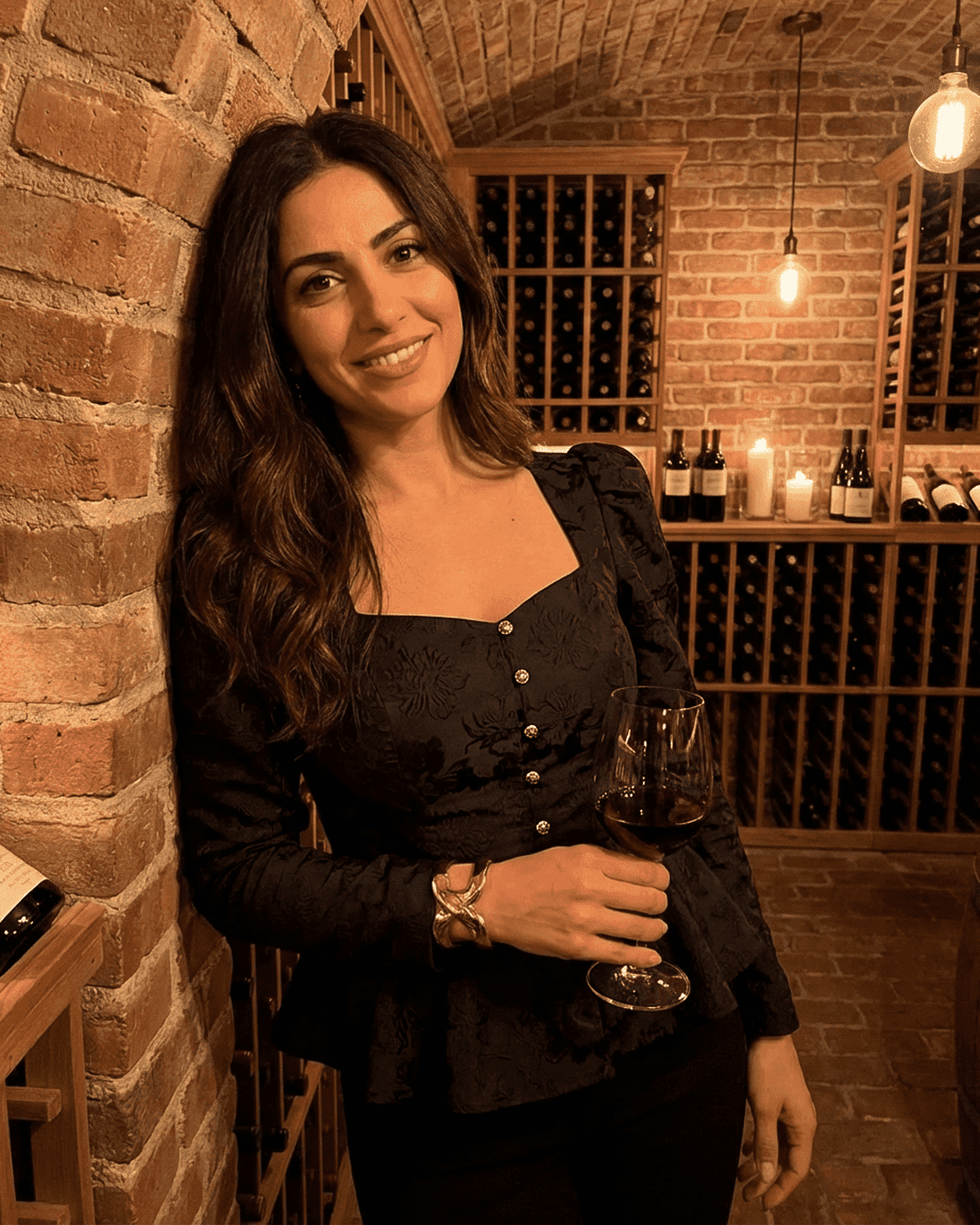 Noir Corset Top by Slimona, featuring a square neck and puff sleeves, elegantly worn with a glass of wine in a wine cellar.