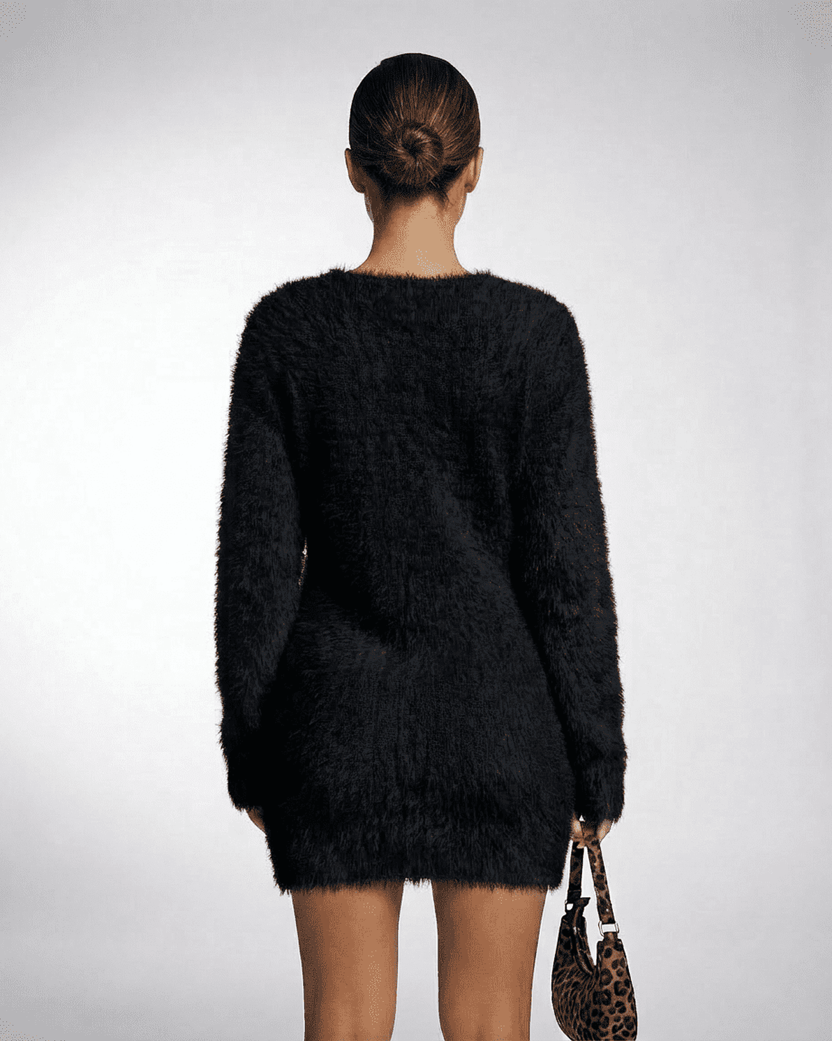 Back view of a model wearing the Slimona Noir Sweater, showcasing its plush texture and loose fit.