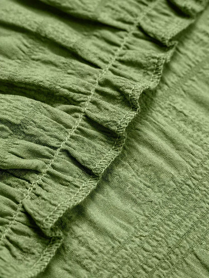 Close-up of the textured ruffled fabric in a soft olive green, perfect for summer dresses and casual wear.