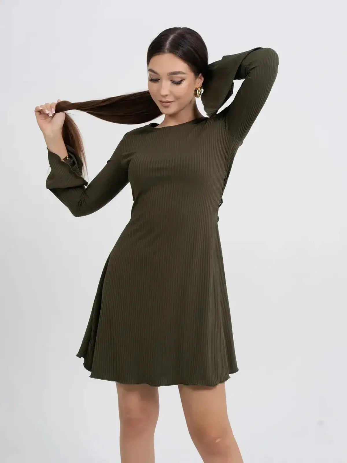 Model wearing Olive Muse long sleeve mini dress in olive green, showcasing a flattering ribbed design.