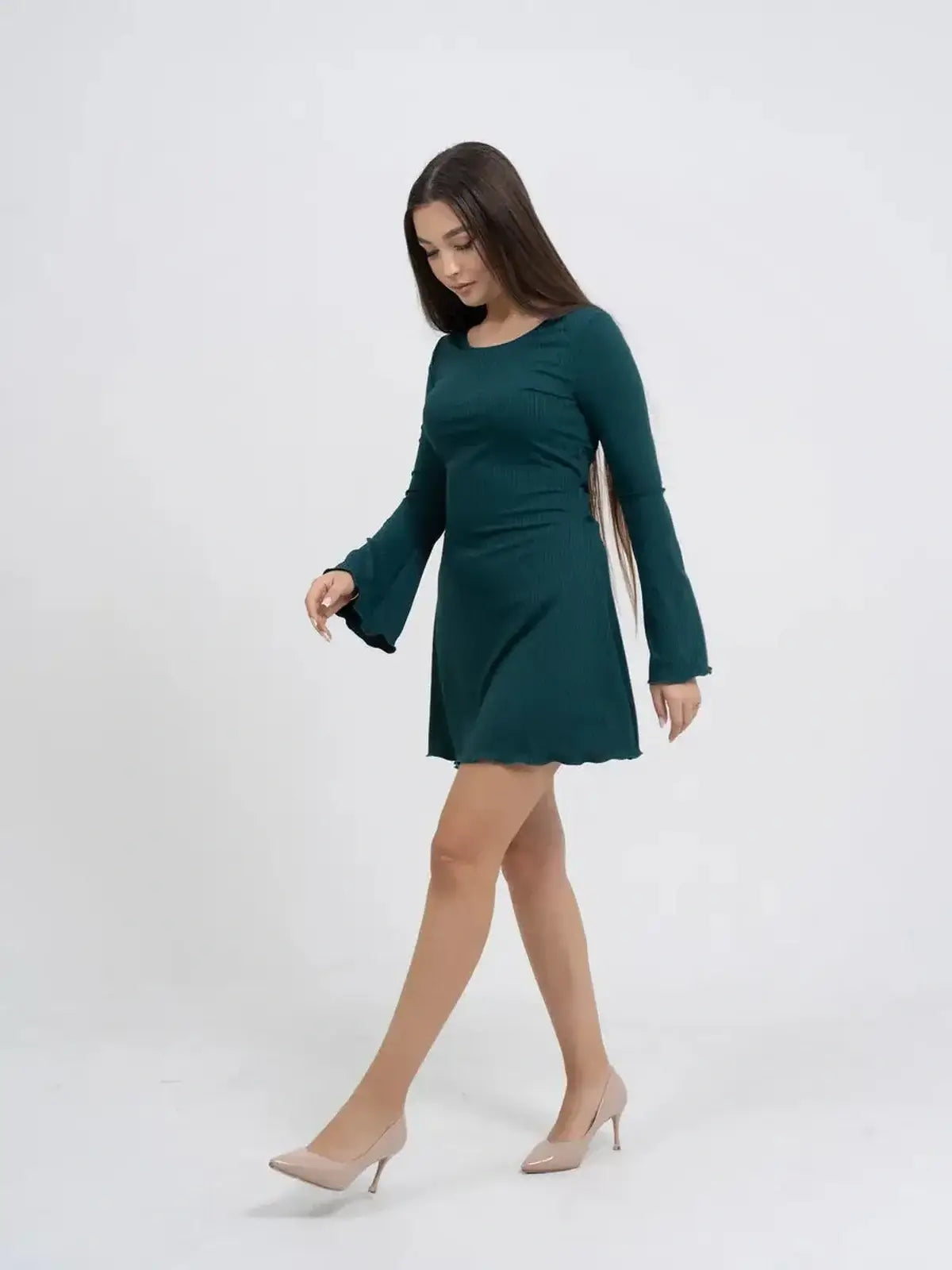 Model showcasing the Olive Muse long sleeve mini dress in emerald green with bell sleeves.