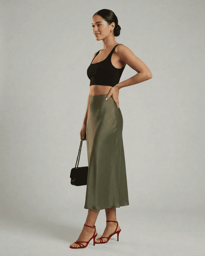 Model displaying the Olivia Midi Skirt by Slimona, featuring a satin mermaid silhouette in olive green.