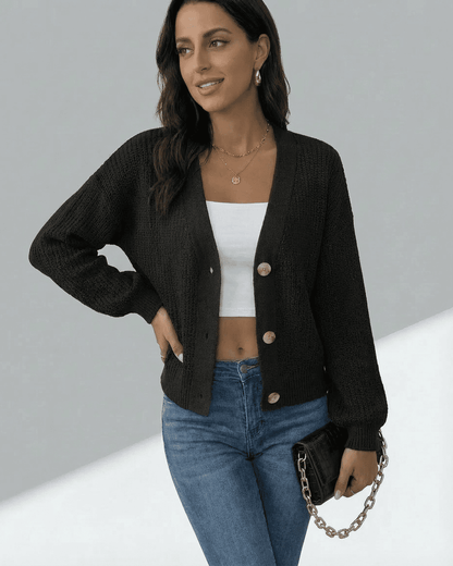 Model wearing Slimona Orion Cardigan, a black long sleeve V-neck knitwear, styled with high-waisted jeans.