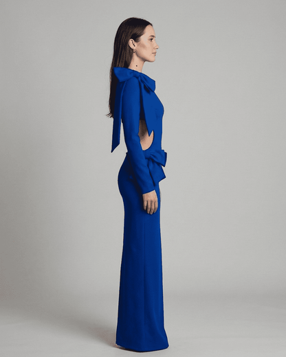 Orion Maxi Dress by Slimona featuring a long sleeve bodycon silhouette with a cut-out waist and sculptural bows in blue.