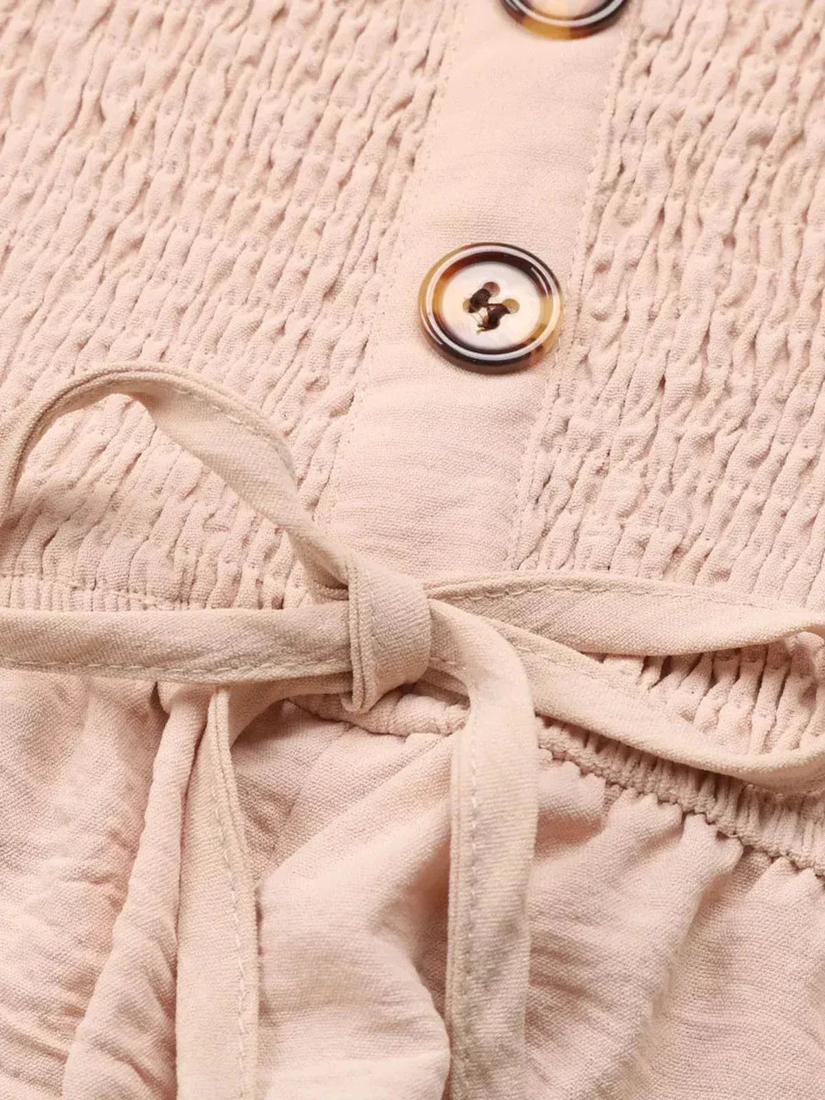 Close-up of the Palm Bay Mini Dress showing a textured strapless bodice and button detail.