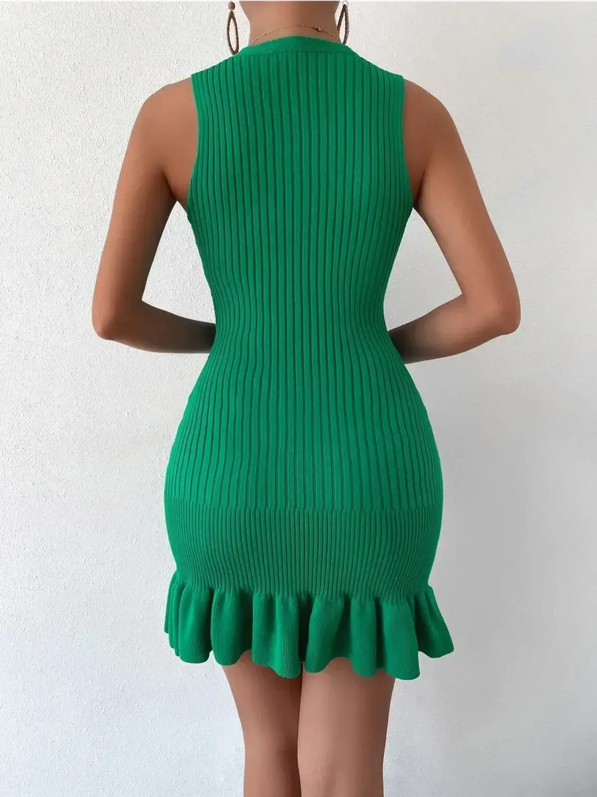 Back view of a green ribbed mini dress with ruffle hem, perfect for summer occasions and casual outings.